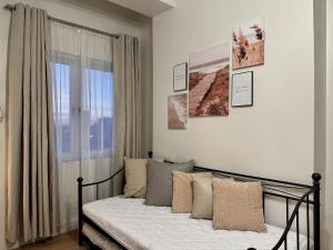 a bedroom with a bed with pillows and a window at 8F Cozy 1-Bedroom Unit The Loop Towers in Cagayan de Oro