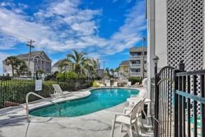 a swimming pool with white chairs next to a building at Seas the day llc in Myrtle Beach