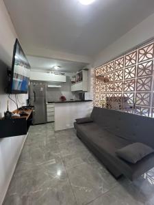 a living room with a couch and a kitchen at Kitnet completa com ar condicionado in São Vicente