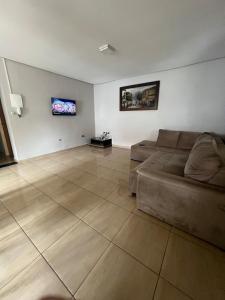 a living room with a couch and a flat screen tv at Casa Lagoa Maior Espaçosa e confortável! in Três Lagoas