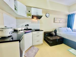 a room with a kitchen with a bed and a counter at 2F Cozy Studio Unit at Aspira Avida Tower 2 in Cagayan de Oro