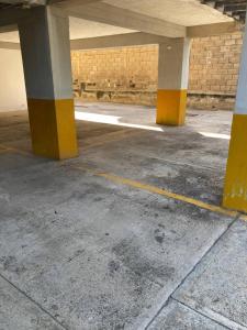 ein leerer Parkplatz mit gelben und weißen Säulen in der Unterkunft Valle Sol in El Valle del Espíritu Santo