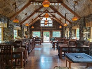SānglaShepherd's Lore Camps & Resort的有木桌椅和窗户的餐厅 更多25张照片