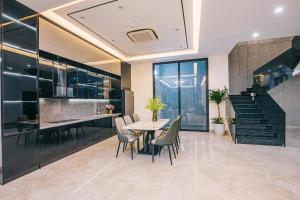 een eetkamer en keuken met een tafel en stoelen bij Lucy Villa Sầm Sơn in Sầm Sơn