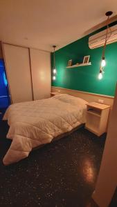 a bedroom with a bed and a green wall at El rinconcito de Lamadrid in Concordia
