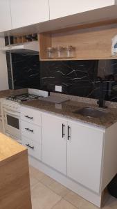 a kitchen with white cabinets and a sink at El rinconcito de Lamadrid in Concordia