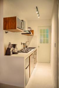 a kitchen with a stove top oven next to a door at Departamento en Aldea Tulum in Tulum
