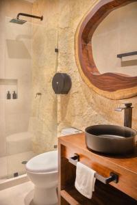 a bathroom with a sink and a toilet and a shower at Departamento en Aldea Tulum in Tulum +4 photos