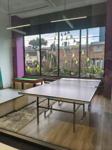 due tavoli da ping pong in una stanza con una grande finestra di Apartamento barrio La Castellana a Bogotá