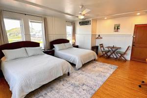 a bedroom with two beds and a table at Hilo Town Inn in Hilo