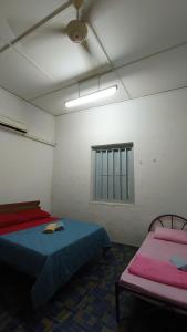 a room with two beds and a window at Lim zhai dormitory3 in Melaka