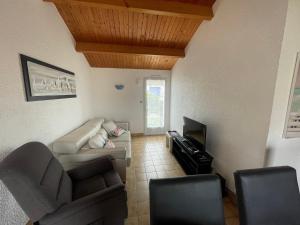 a living room with a couch and a tv at Charmant pavillon avec jardin clos, terrasse, et tout confort, à 950m de la plage des Sables-d'Olonne - FR-1-92-743 in La Pironnière