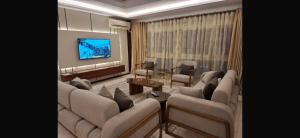 a living room with couches and a flat screen tv at Deluxe Direct Nile Apartment in Cairo