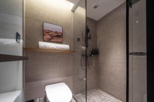 ein Bad mit einer Duschkabine und einem WC in der Unterkunft Atour Hotel Dalian Xinghai Square Zhongshan Road in Dalian