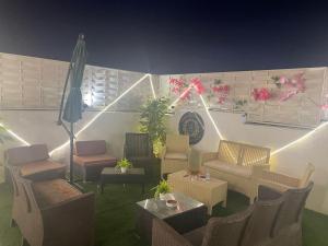 a living room with chairs and tables and an umbrella at منازل سارا 2 Sara Houses in Tabuk