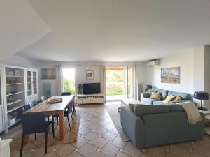 a living room with a couch and a table at Maison 6 pers. avec jardin, terrasse, 2 piscines et parking - Alpilles/Luberon - FR-1-658-23 in Mallemort