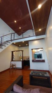 a living room with a staircase and a couch and a table at Skypiea Dieng in Dieng