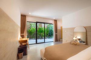a bedroom with a bed and a large window at Nooju Pererenan in Canggu +44 photos