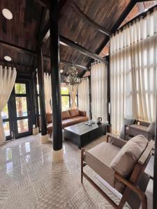 a living room with a bed and a couch at Bently farm retreat Mũi Né-Premium Bungalow-05 in Ấp Phú Hiệp