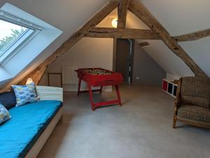 una camera con letto e tavolo in mansarda di Maison familiale au bord de la Loire à Sigloy pour 6 personnes - FR-1-590-572 a Sigloy