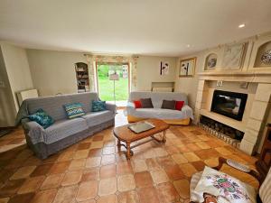a living room with two couches and a fireplace at Gîte Tourangelle avec Piscine Intérieure, Wifi, Jardin - FR-1-381-619 in Assay