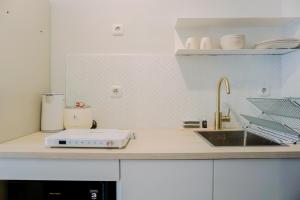 a kitchen counter with a toaster and a sink at Stunning Studio Transpark Bintaro Apartment By Travelio in Tangerang