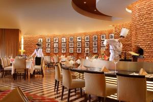 a restaurant with a chef preparing food in a dining room at Ningbo Portman Plaza Hotel in Ningbo