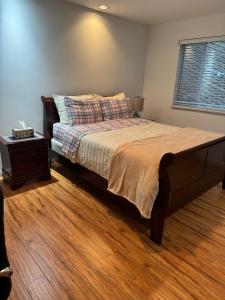 a bedroom with a large bed with a wooden floor at Beautiful Two Bedroom Suite in North Vancouver +37 photos