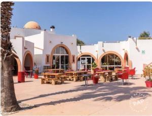a patio with tables and chairs in front of a building at Mobil home haut de gamme 6 personnes camping 4 étoiles Marvilla Parks BARCARES plage in Torreilles