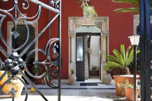 an entrance to a red building with potted plants at Villa Astoria in Taormina