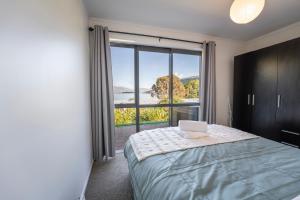 a bedroom with a laptop on a bed with a window at Lakeview Haven in Queenstown