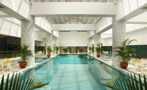 a large swimming pool in a building with plants at Ningbo Portman Plaza Hotel in Ningbo