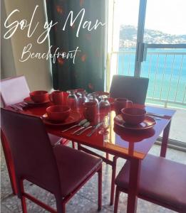 a wooden table with red cups and bowls on it at Torres Gemelas Acapulco Suites in Acapulco