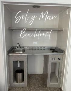 a kitchen with a sink and a sign that says getty man beautiful at Torres Gemelas Acapulco Suites in Acapulco