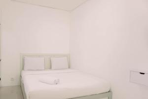 Postel nebo postele na pokoji v ubytování Cozy Stay Studio at Urbantown Serpong Apartment By Travelio + 7 fotografií