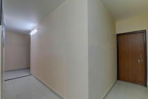 a hallway with a wooden door and a wall at FabHotel Raas Inn in Lucknow