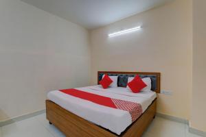 a bedroom with a bed with red pillows on it at FabHotel Raas Inn in Lucknow