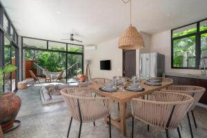 a dining room with a wooden table and chairs at 2 Tropical Bohemian Villas-2 Priv Pool-BBQ 3A-3B in Tulum