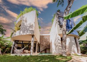 an exterior view of a stone house with a tree at 2 Tropical Bohemian Villas-2 Priv Pool-BBQ 3A-3B in Tulum