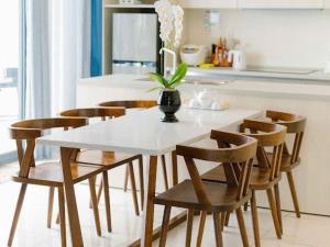 a white table with chairs and a vase on it in a kitchen at Oceanami Luxury Villa in Long Hai