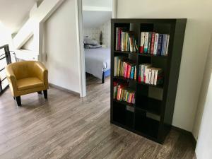a book shelf filled with books next to a bedroom at Le Jardin de Rose et Capucine, piscine et jardin avec terrasse in Gérardmer