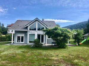 a house with a bench in a yard at Le Jardin de Rose et Capucine, piscine et jardin avec terrasse in Gérardmer