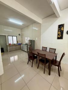 a kitchen and dining room with a wooden table and chairs at AzzaleaHomes 7 Cameron Highlands in Brinchang