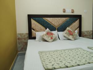 una camera con letto bianco e cuscini di "Om Sadan" Guest House Ayodhya Dhaam a Ayodhya