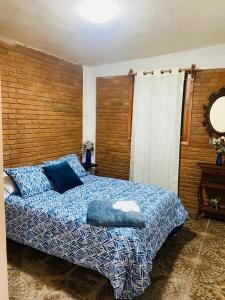 a bedroom with a bed with a blue and white blanket at Cabaña rodeada de naturaleza in Pátzcuaro