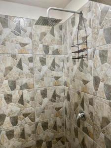 a bathroom with a shower with a tiled wall at Cabaña rodeada de naturaleza in Pátzcuaro