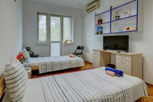 a room with two beds and a flat screen tv at Steady - Guests Rooms in Varna City +43 photos