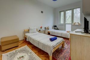 a room with two beds and a tv in it at Steady - Guests Rooms in Varna City