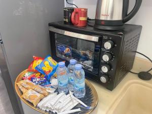 a plate with water bottles in front of a microwave at منازل سارا 3 Sara Houses in Tabuk