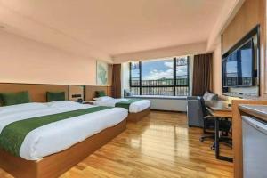 a hotel room with two beds and a desk at GreenTree Inn Tangshan Nanhu International Exhibition Center in Tangshan +193 photos